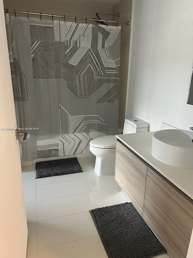 bathroom with tile floors, toilet, and vanity