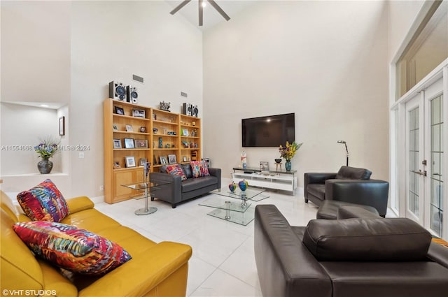 tiled living room featuring ceiling fan and a towering ceiling