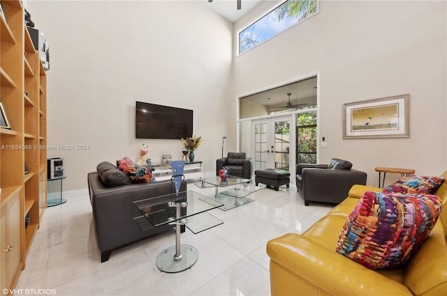 tiled living room featuring french doors, ceiling fan, and a high ceiling