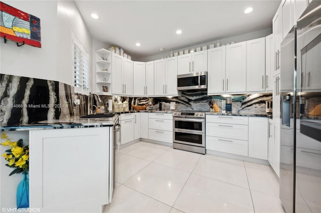 kitchen featuring backsplash, white cabinets, appliances with stainless steel finishes, and sink