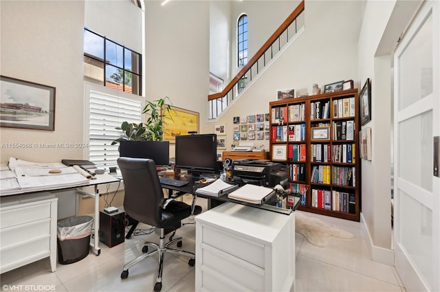 home office with a high ceiling and light tile floors