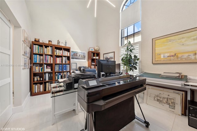 tiled office space featuring plenty of natural light and a towering ceiling