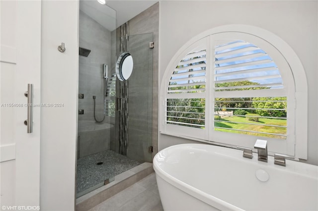 bathroom featuring tile flooring and separate shower and tub