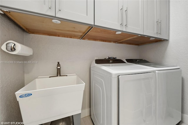 laundry room with washer and clothes dryer, cabinets, sink, and hookup for a washing machine