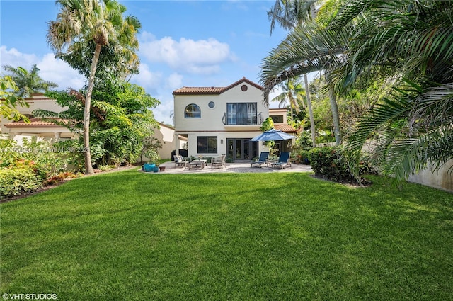 rear view of house with a lawn and a patio area