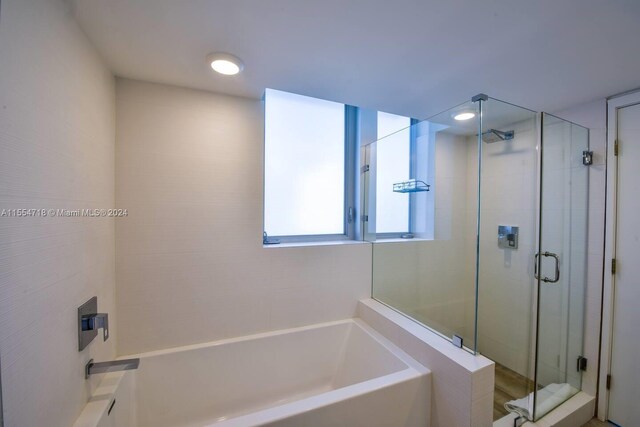 bathroom featuring shower with separate bathtub