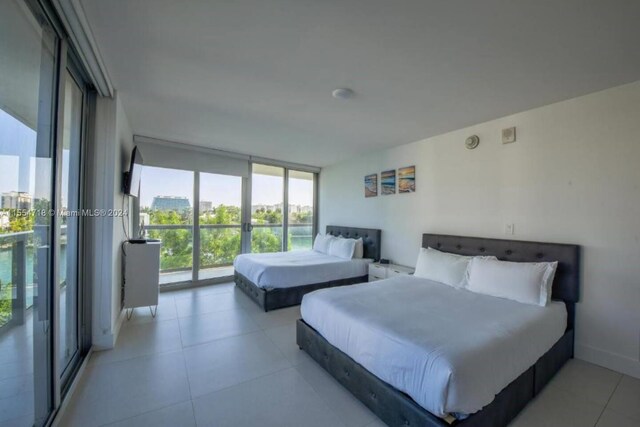 tiled bedroom featuring a wall of windows