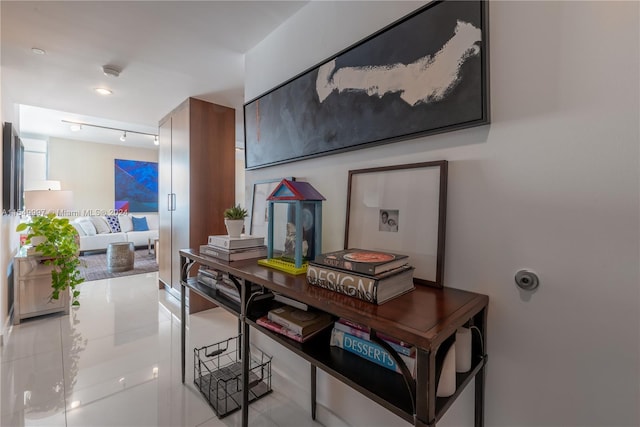 hallway featuring light tile floors and track lighting