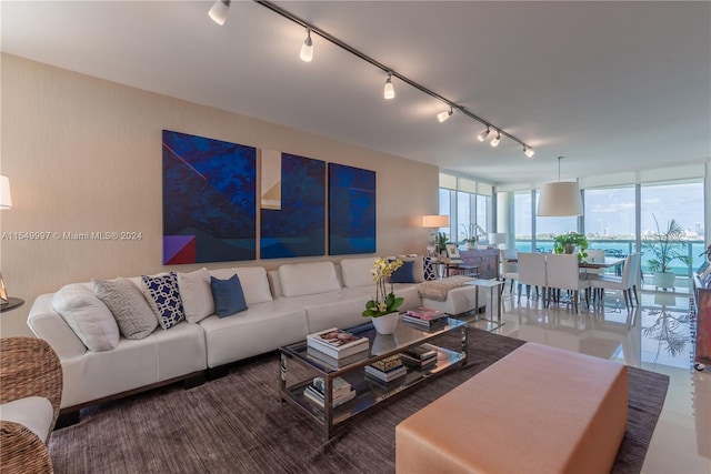 tiled living room with rail lighting and a wall of windows