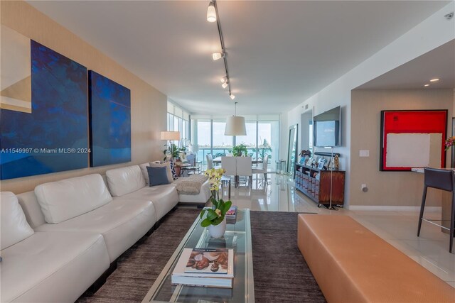 living room with rail lighting and light tile floors