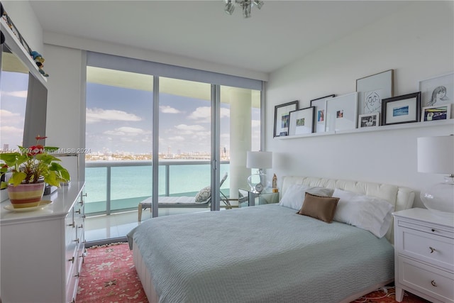 bedroom featuring a water view and access to exterior