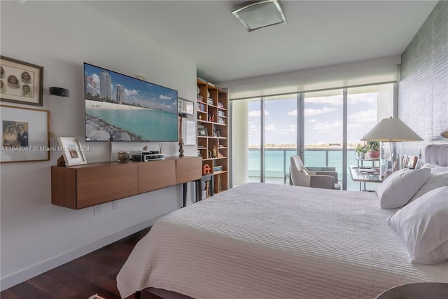 bedroom with access to outside, dark hardwood / wood-style flooring, and a water view