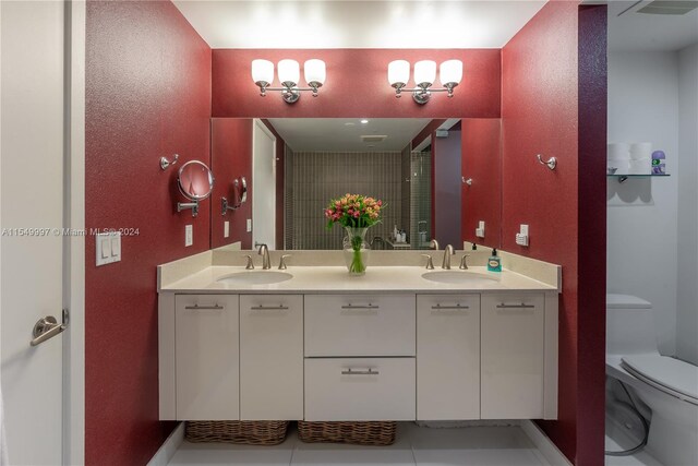 bathroom featuring toilet, double vanity, and tile floors