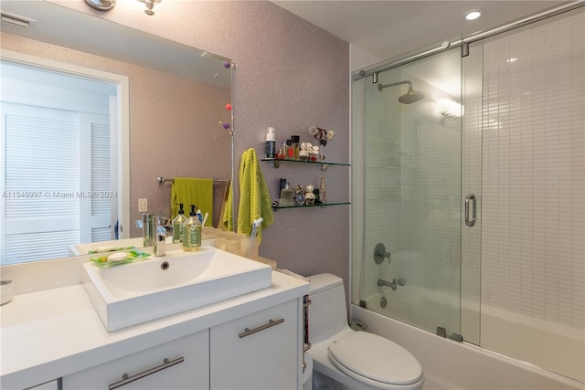 full bathroom with vanity, enclosed tub / shower combo, and toilet