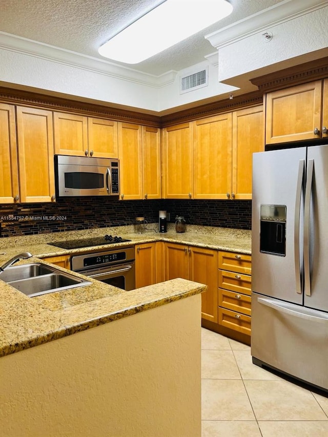 kitchen with backsplash, a textured ceiling, appliances with stainless steel finishes, and sink