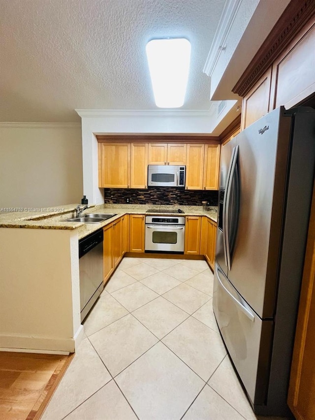 kitchen featuring kitchen peninsula, tasteful backsplash, appliances with stainless steel finishes, crown molding, and sink