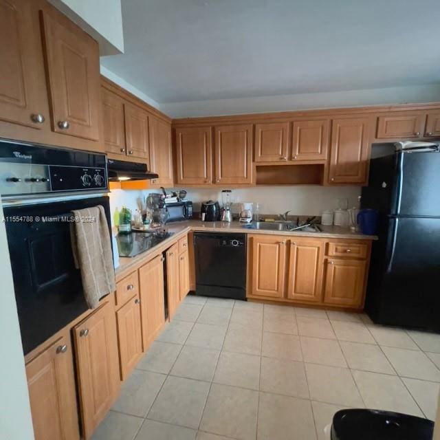 kitchen featuring light tile floors, black appliances, and sink