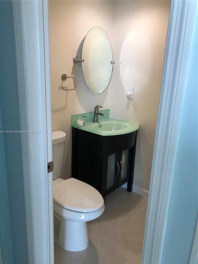 bathroom featuring sink, tile floors, and toilet