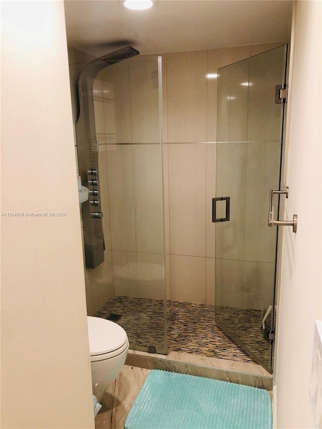 bathroom featuring walk in shower, toilet, and tile flooring