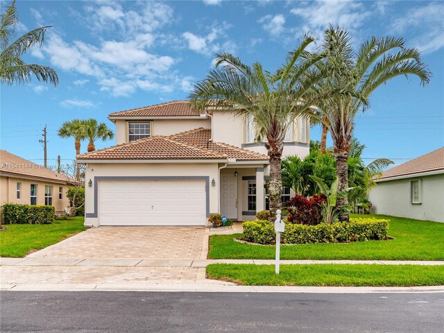 mediterranean / spanish-style home featuring a garage and a front yard