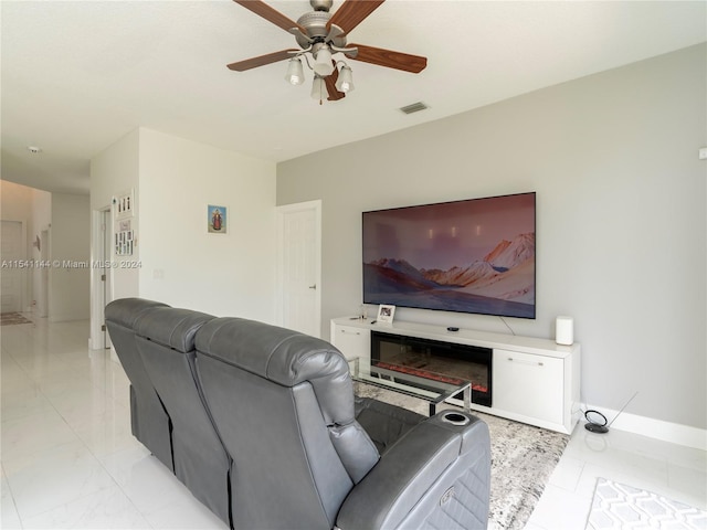 living area featuring a ceiling fan, visible vents, and baseboards