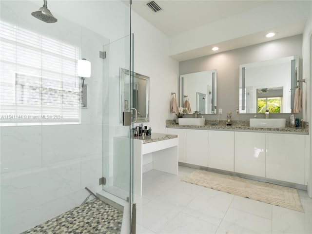 bathroom featuring a sink, visible vents, marble finish floor, a marble finish shower, and double vanity