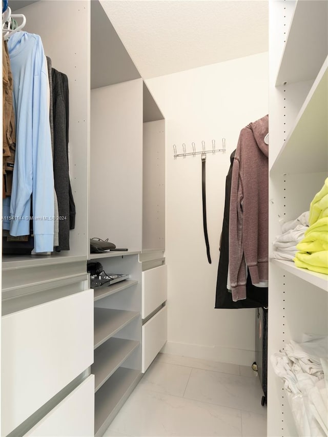 spacious closet featuring marble finish floor