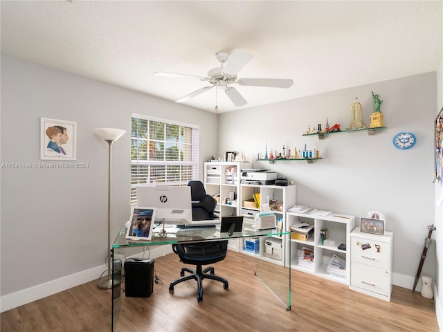 home office featuring ceiling fan, a textured ceiling, baseboards, and wood finished floors