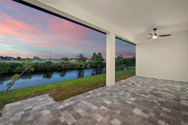 view of patio featuring a water view and ceiling fan