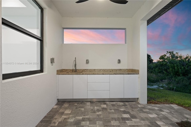 interior space featuring a ceiling fan and a sink