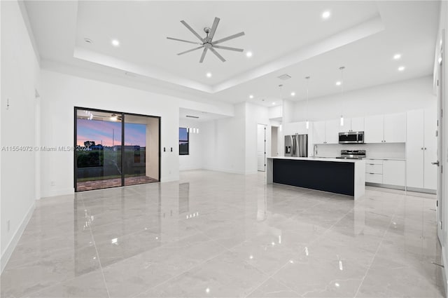 kitchen featuring a center island with sink, appliances with stainless steel finishes, open floor plan, light countertops, and pendant lighting