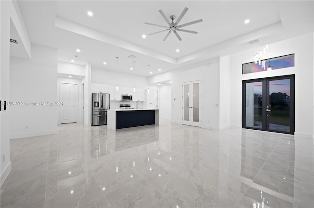 unfurnished living room with french doors, marble finish floor, a raised ceiling, visible vents, and baseboards