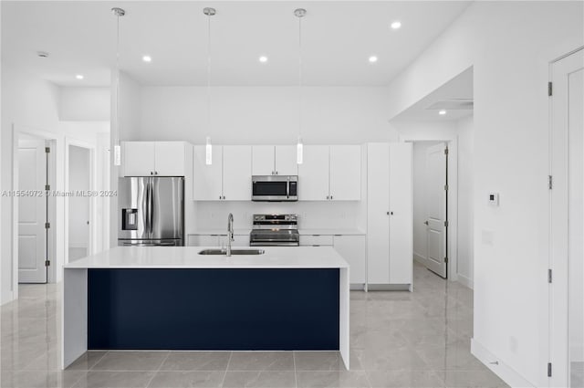 kitchen with appliances with stainless steel finishes, light countertops, decorative light fixtures, and a sink