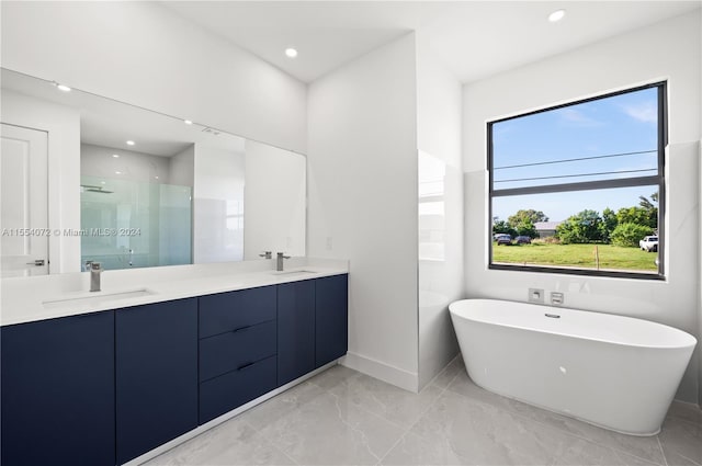 bathroom featuring double vanity, a stall shower, a sink, and a soaking tub