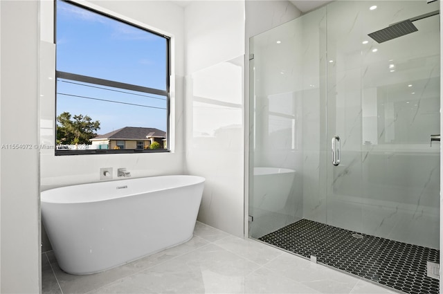 bathroom with marble finish floor, a freestanding tub, and a marble finish shower