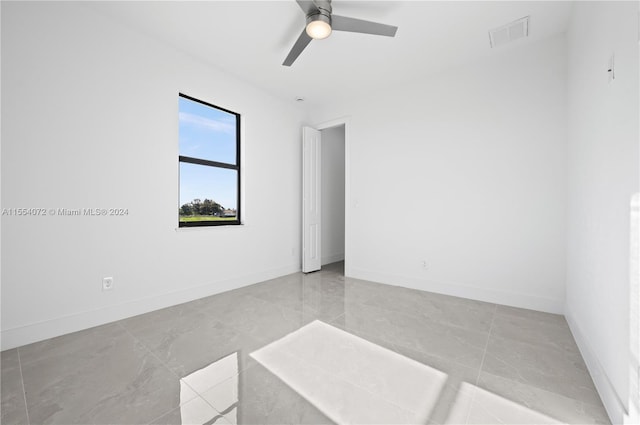 empty room with a ceiling fan, visible vents, and baseboards