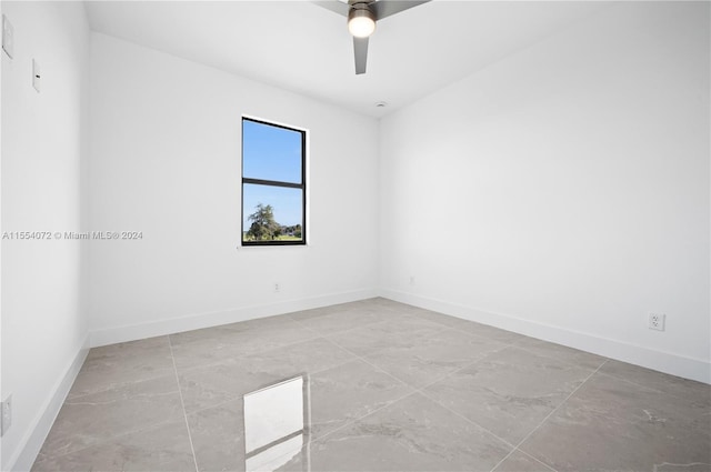 unfurnished room with ceiling fan and baseboards