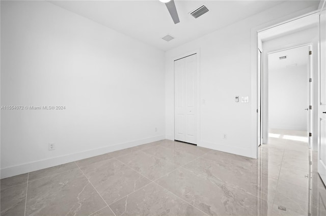 unfurnished bedroom featuring a ceiling fan, baseboards, visible vents, and a closet