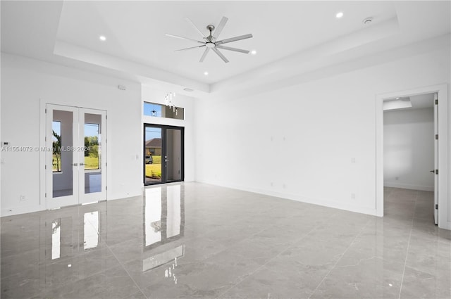 spare room featuring a tray ceiling, french doors, and marble finish floor