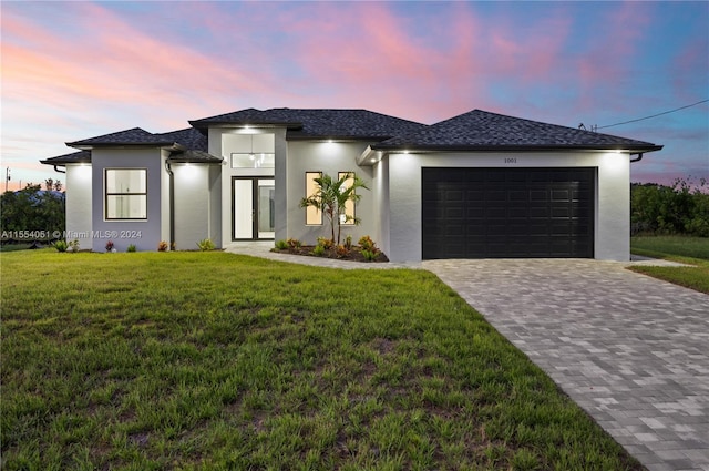 view of front facade featuring a garage and a lawn