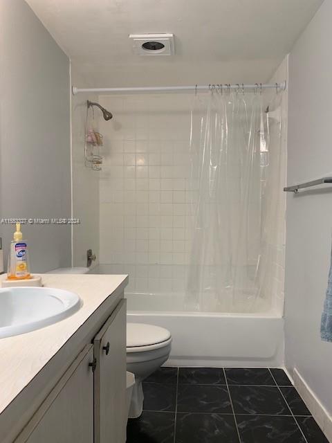 full bathroom featuring toilet, tile floors, shower / bathtub combination with curtain, and vanity