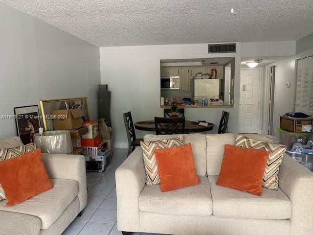 living room with a textured ceiling and light tile flooring