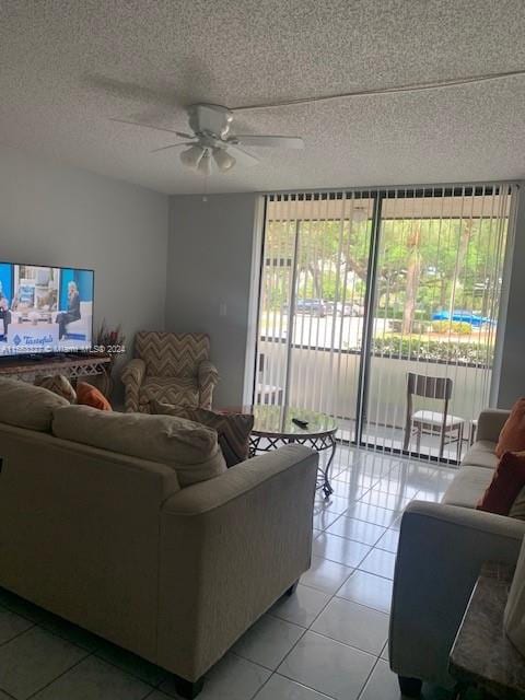 living room featuring a textured ceiling, ceiling fan, and light tile flooring