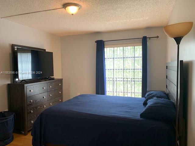 bedroom featuring a textured ceiling and wood-type flooring