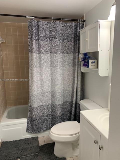 full bathroom with shower / tub combo, toilet, tile flooring, and vanity