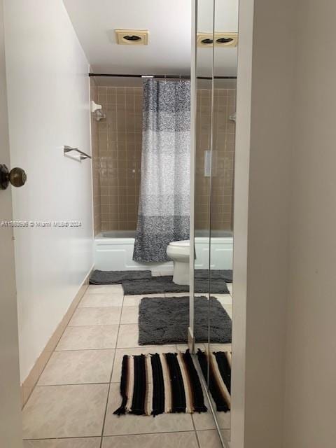 bathroom featuring tile flooring and toilet