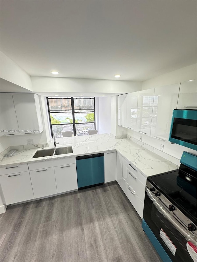 kitchen featuring appliances with stainless steel finishes, light hardwood / wood-style floors, sink, white cabinetry, and light stone countertops