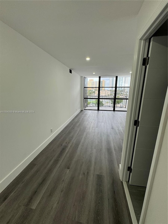 hallway featuring a wall of windows and dark hardwood / wood-style floors