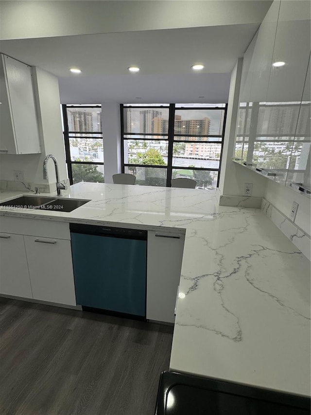 kitchen with white cabinetry, sink, light stone counters, stainless steel dishwasher, and dark hardwood / wood-style flooring