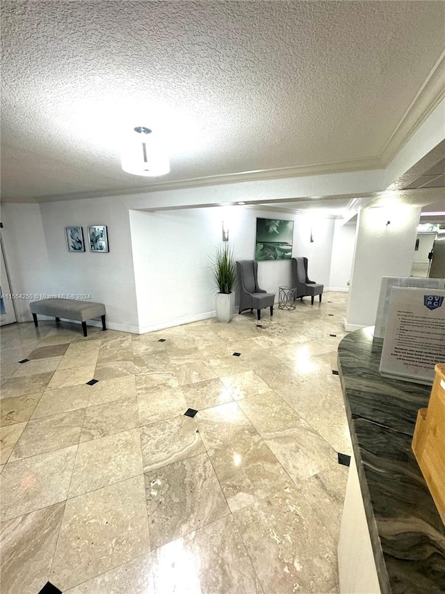 interior space with a textured ceiling, ornamental molding, and light tile flooring